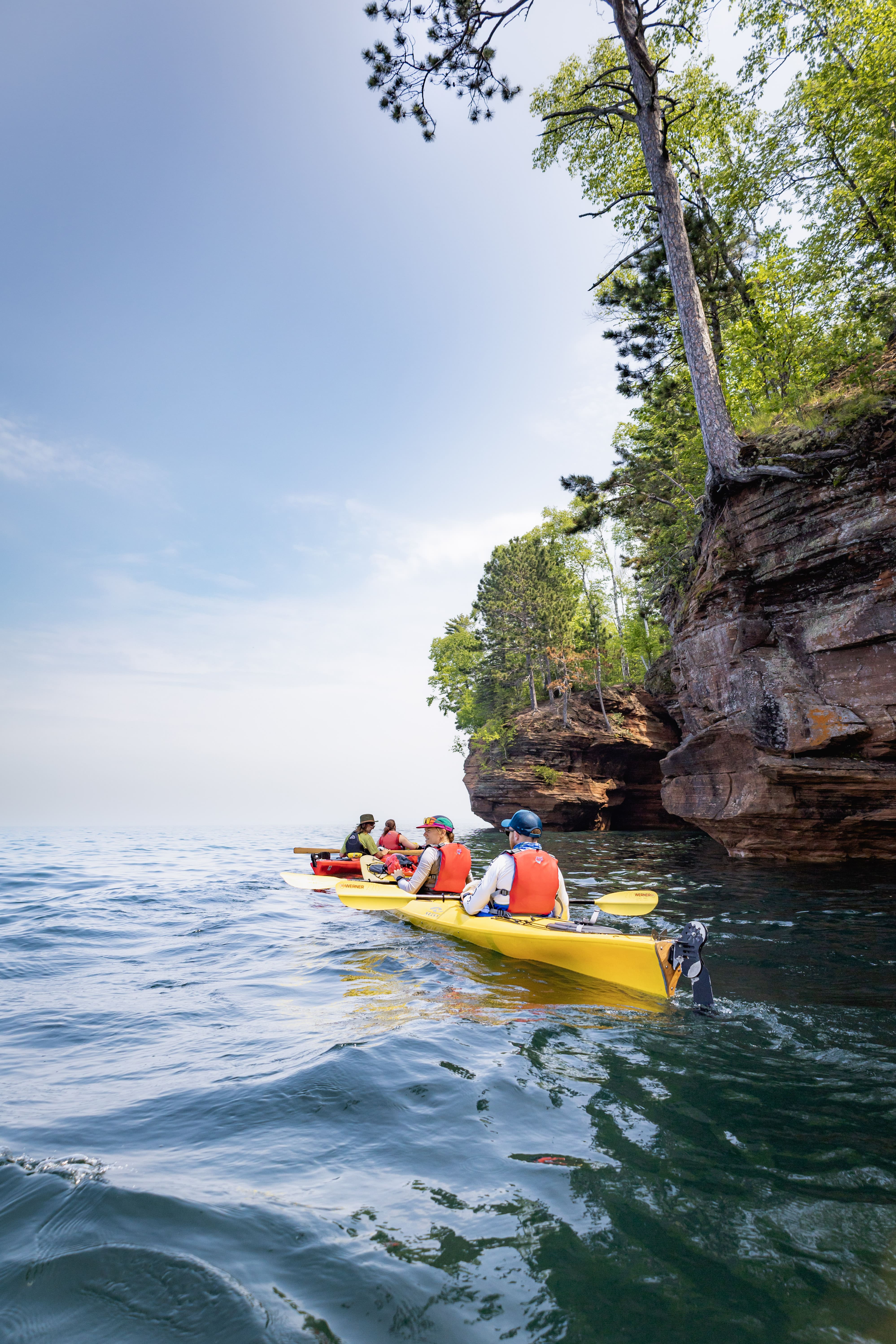 kayaks on a lake in front of sea caves