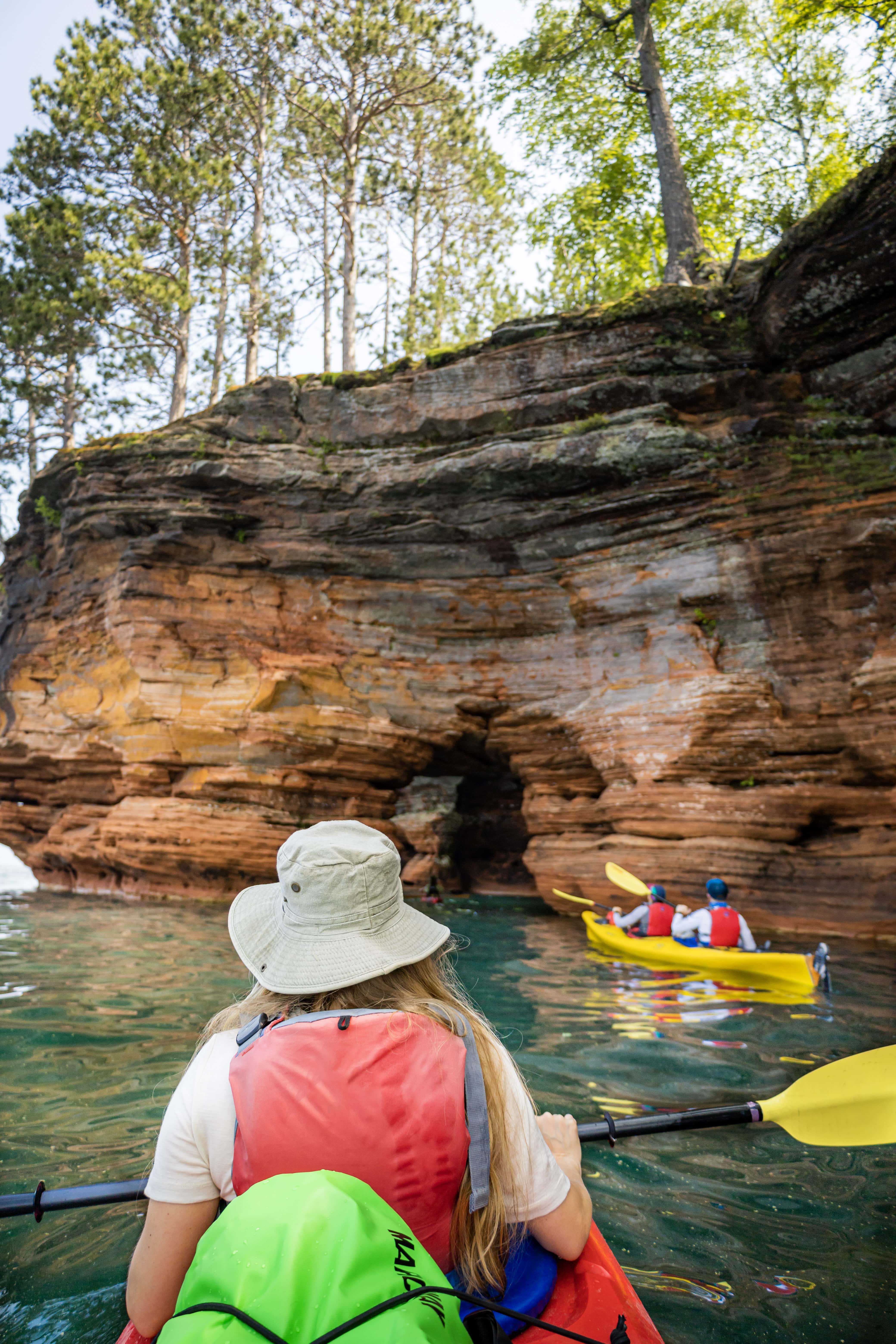 kayaks on a lake in front of sea caves