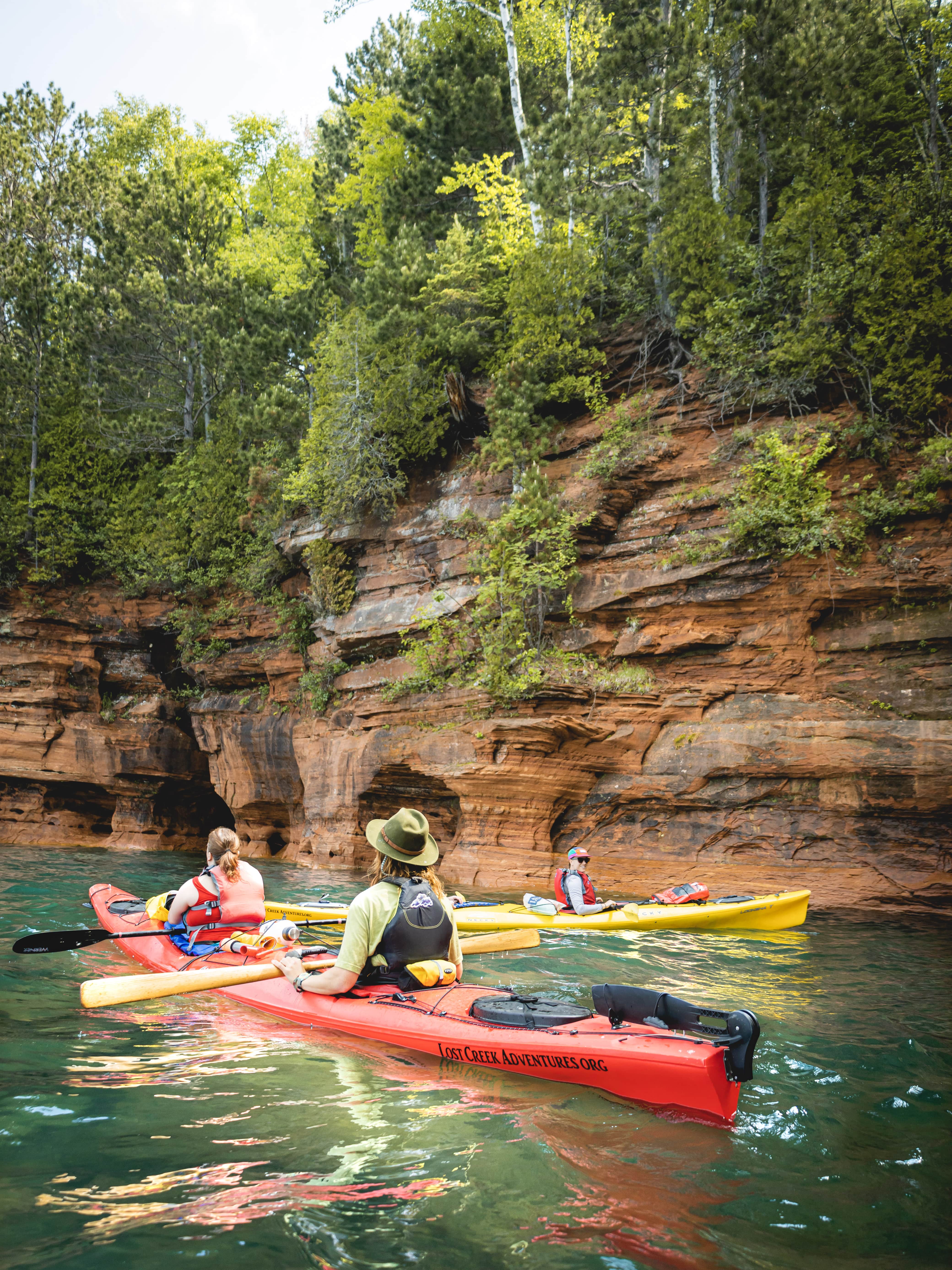 kayaks on a lake in front of sea caves