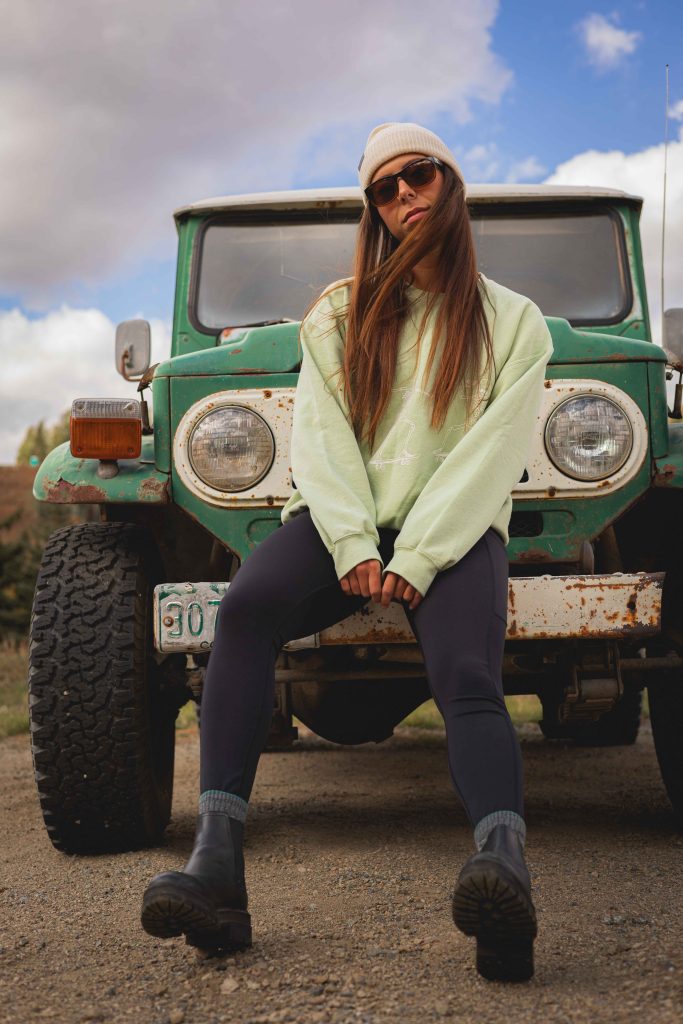 woman sitting on a teal car
